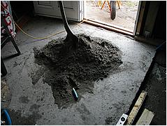 Sand og cement bliver blandet p� gulvet.